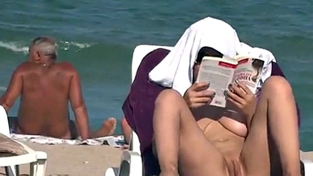 男はビーチで主婦の裸の体に興味を持っています