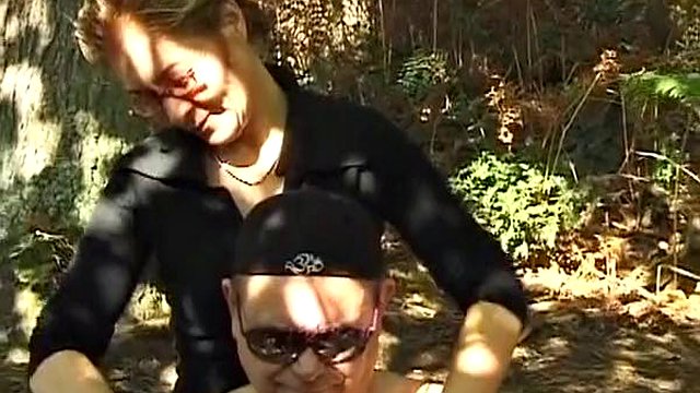 A mature German domina spanks her man in the woods