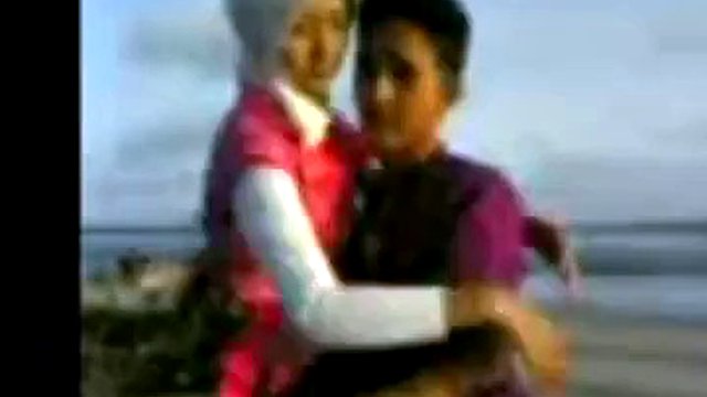Chica indonesia con hijab folla en la playa
